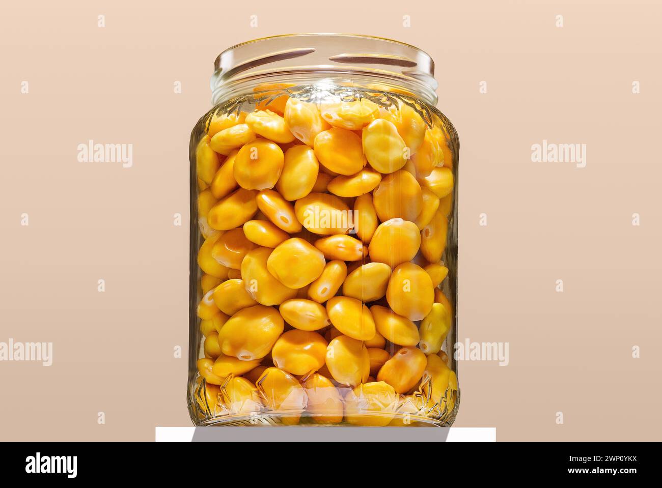 Glass jar filled with lupini beans in a bright environment, captured