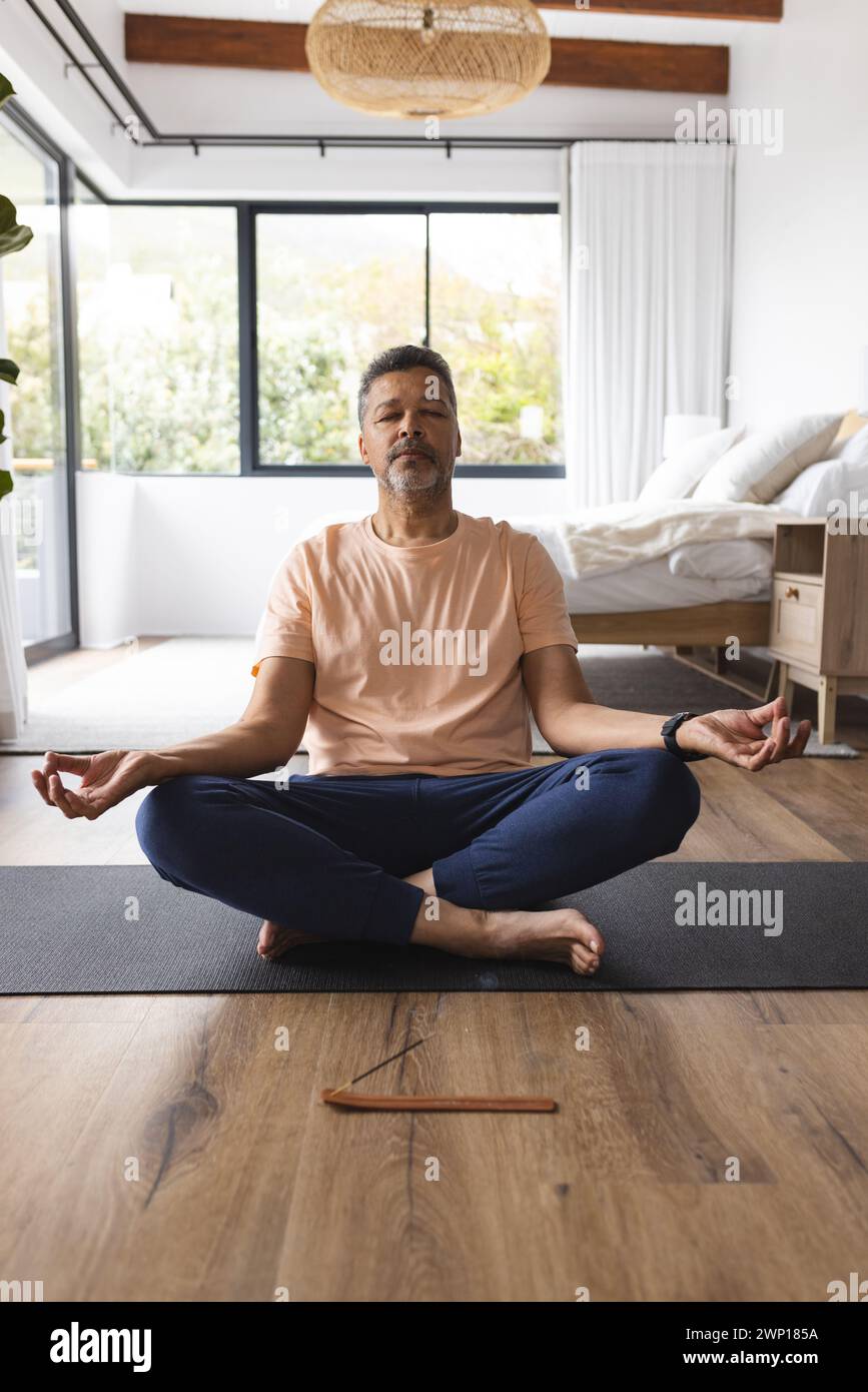 Biracial senior man meditates in a peaceful home setting, exuding tranquility Stock Photo