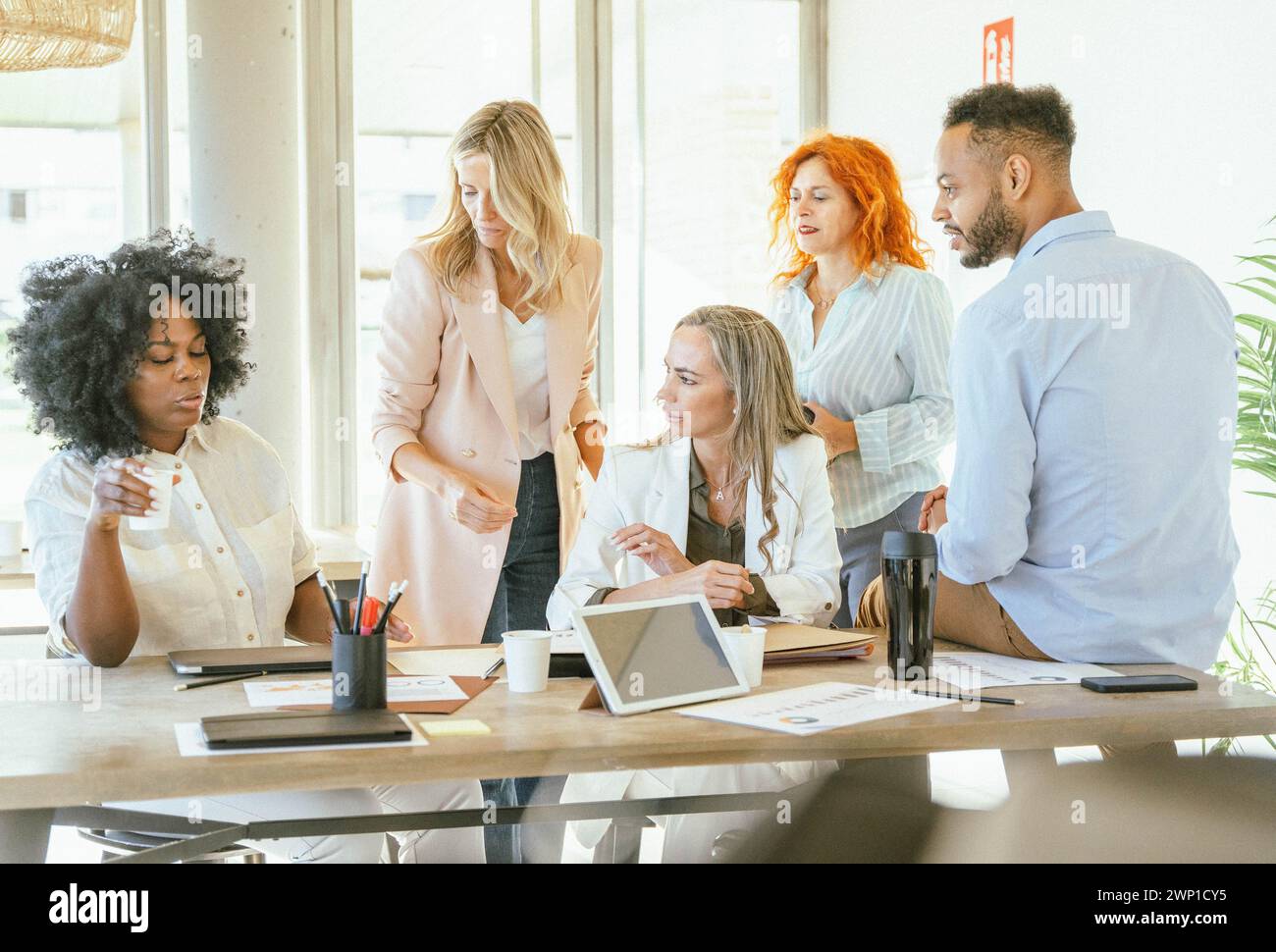 Businesswoman talking to her colleagues while gathering in the meeting room. Business concept. Stock Photo