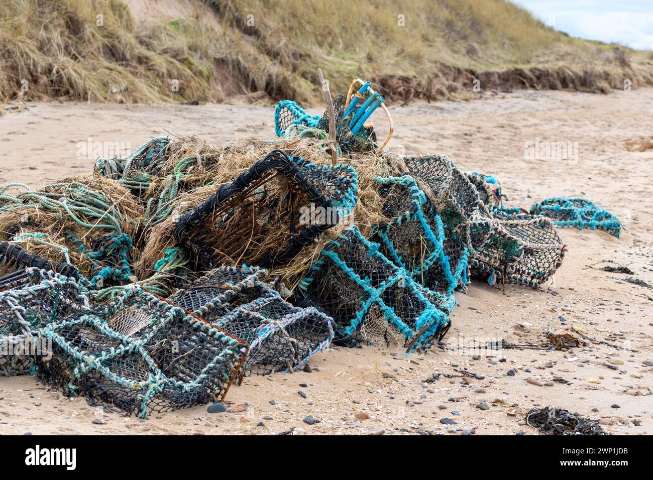 Old lobster pots / creels and fishing nets piled up on a North Berwick Beach Stock Photo