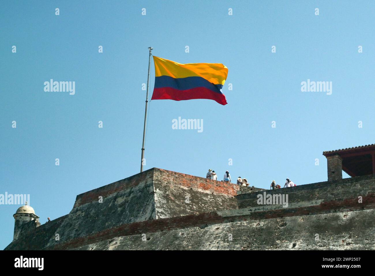 Cartagena, Bolivar, Colombia - 24 January 2024: Visitors below the national flag of Colombia on the historic castle Castillo San Felipe de Barajas Stock Photo