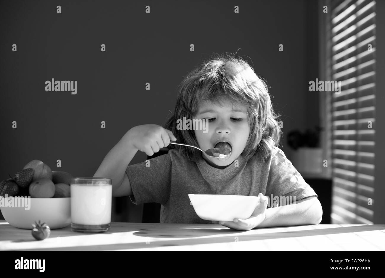 Closeup face of kid eating organic food, yogurt, milk. Child healthy
