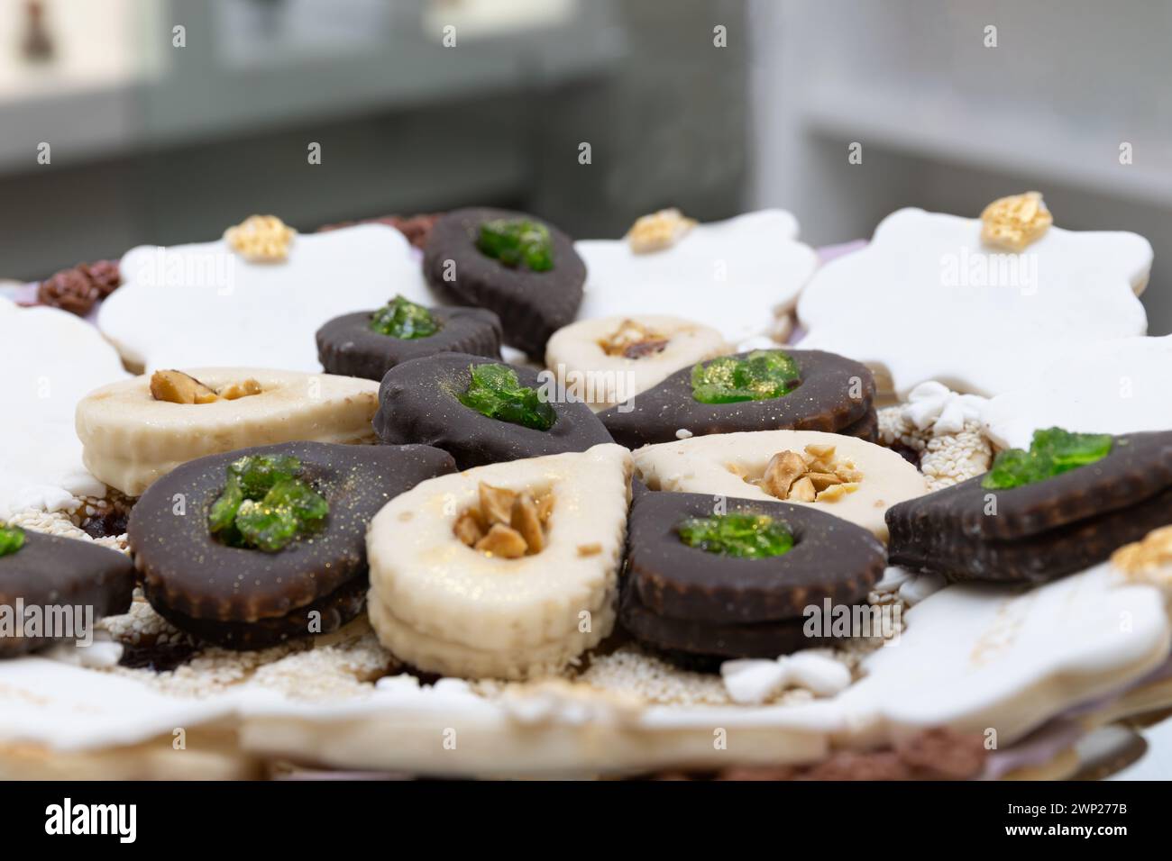 Horizontal photo artisanal Arabic sweets, chocolate and vanilla flavored, adorned with nuts and mint, presented on a traditional white plate. Food and Stock Photo