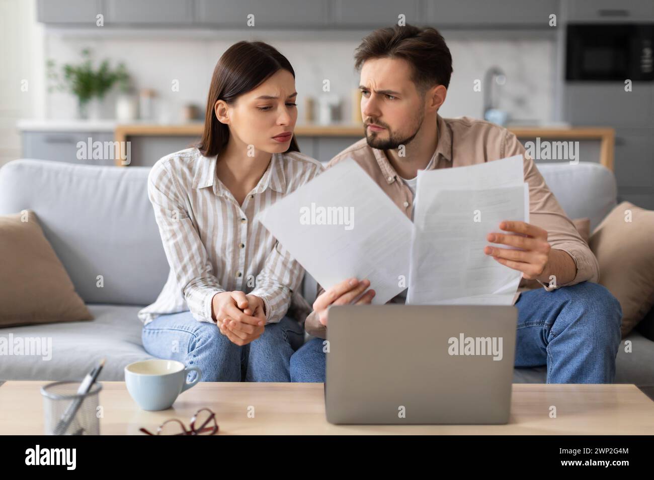 Young couple reviewing documents with concern Stock Photo