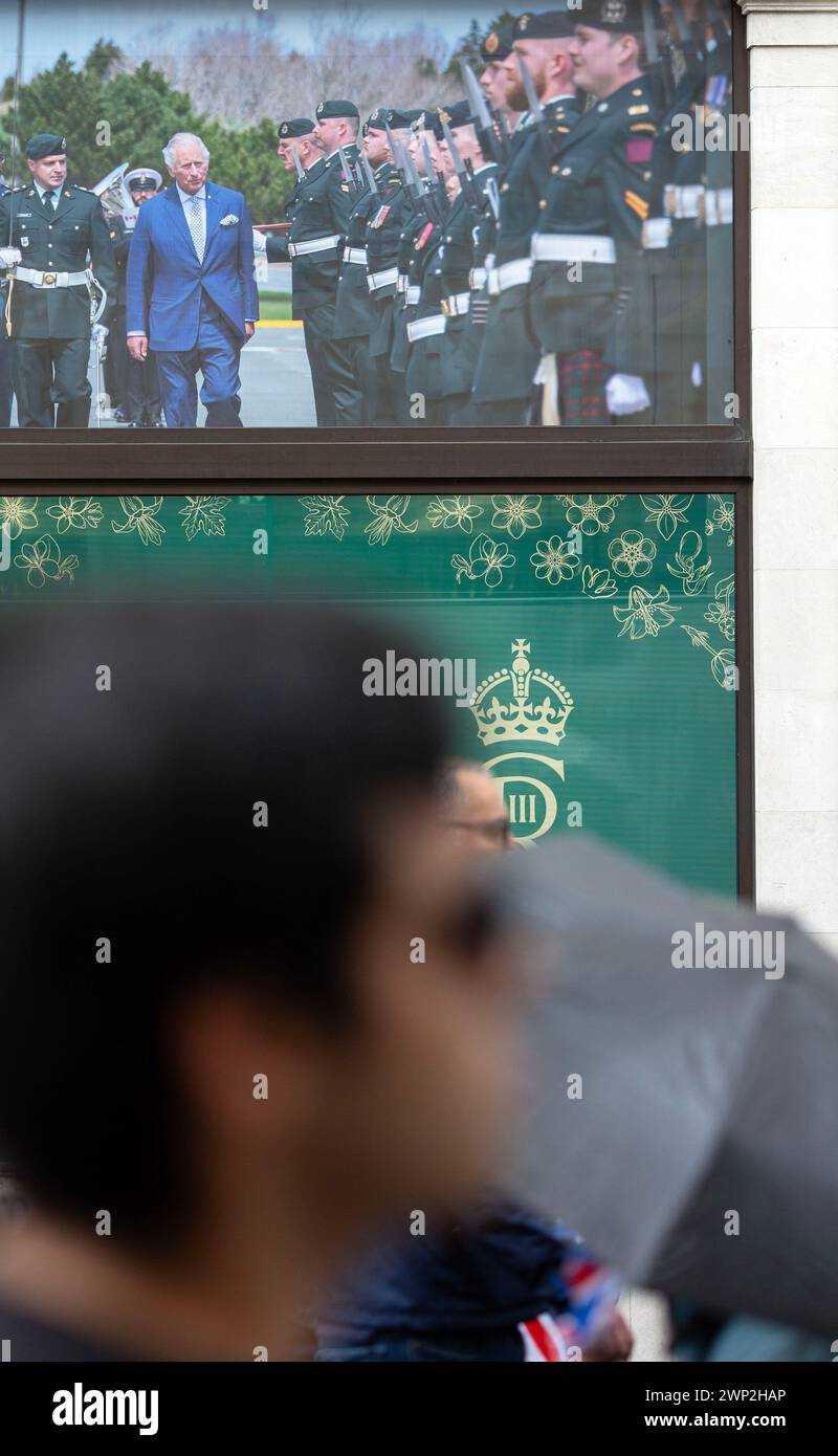 People gather to view the coronation of King Charles III in London. Stock Photo