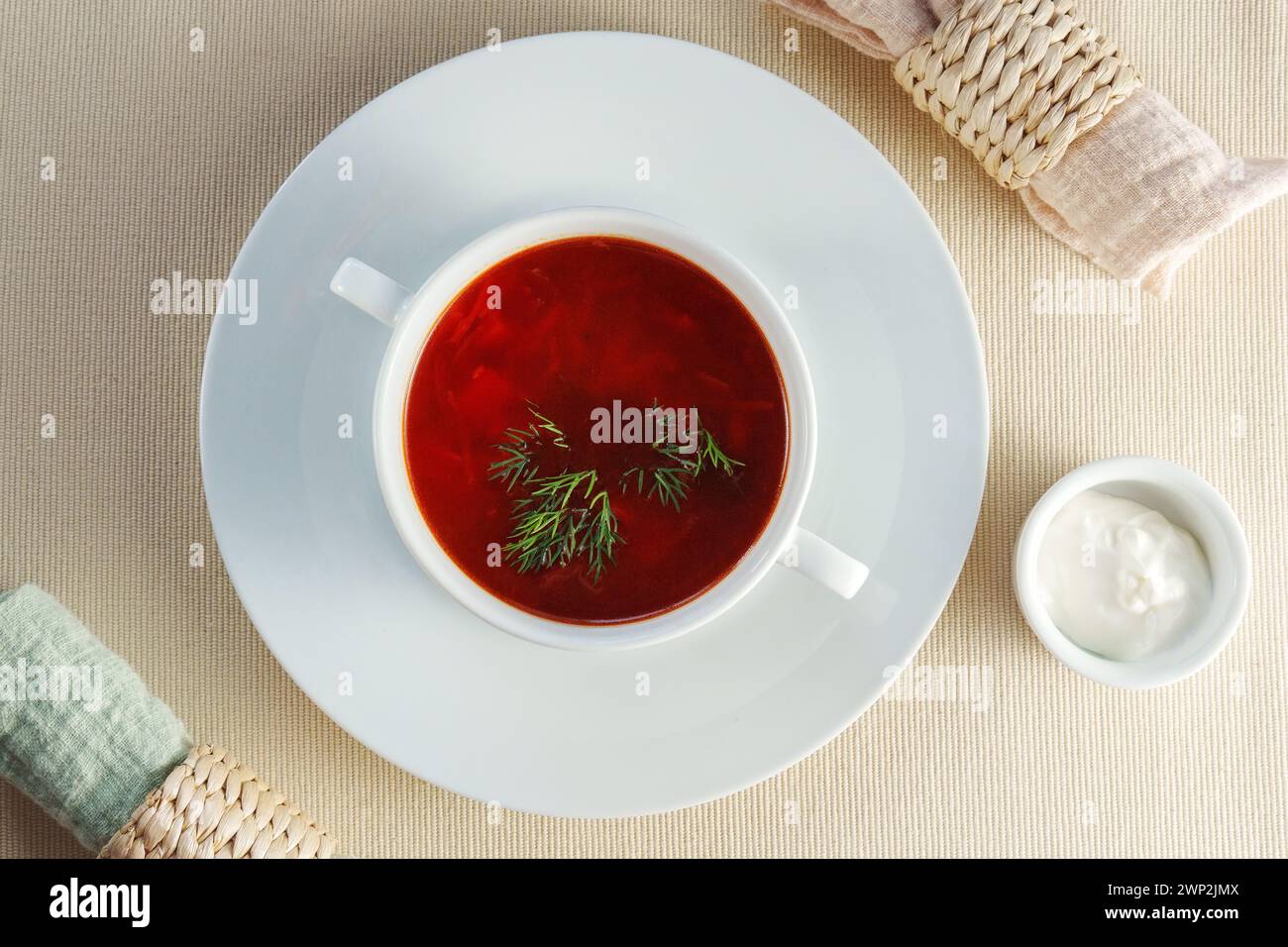 Presented bowl of creamy tomato bisque soup, adorned with a gleaming silver spoon. Stock Photo