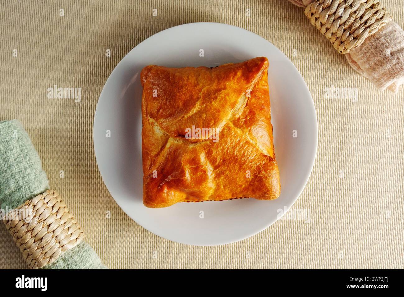 Delicate Delights: A Flaky Puff Pastry Placed Elegantly on a Gleaming White Plate Stock Photo