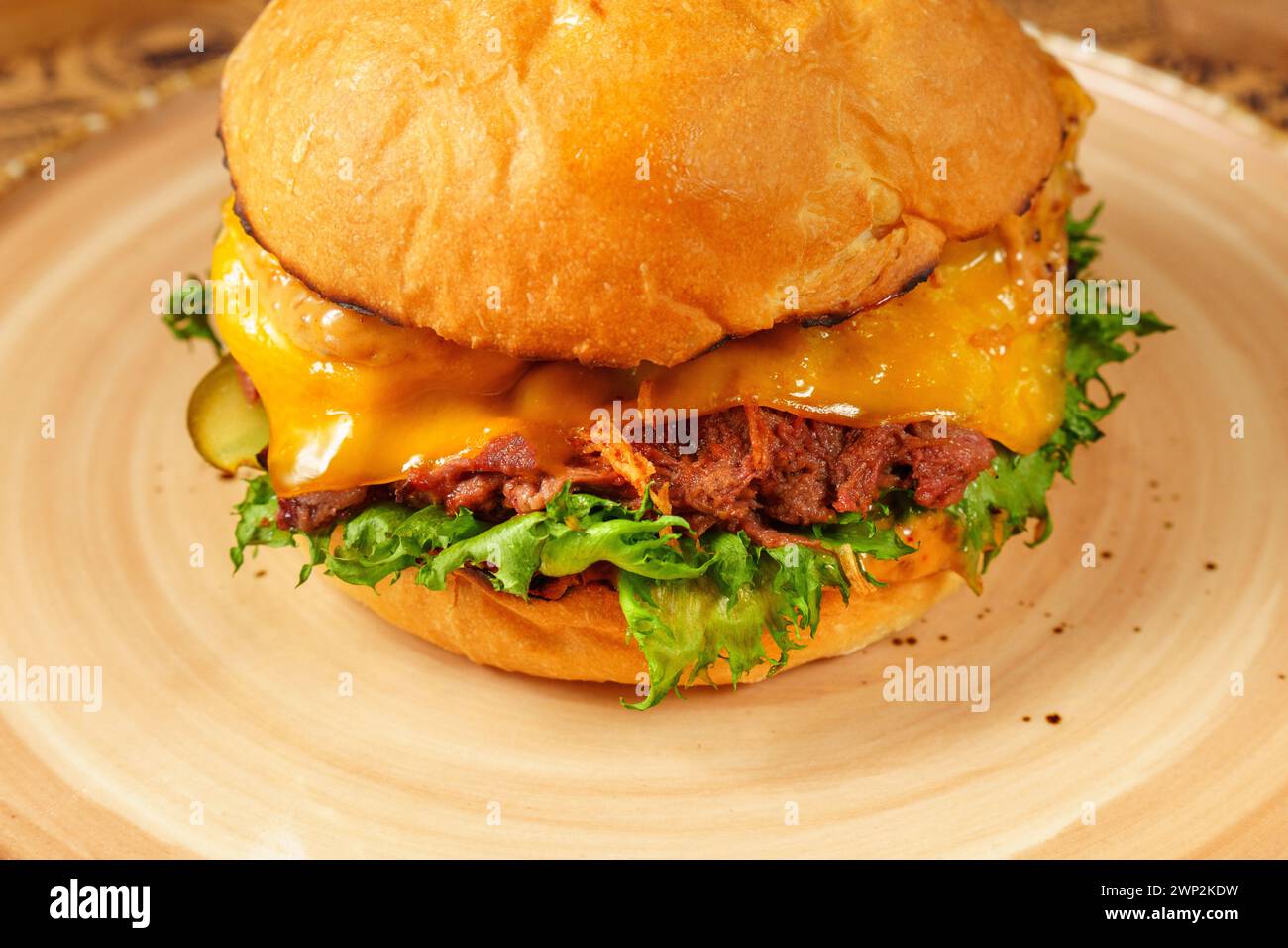 Delicious Cheeseburger With Lettuce and Toppings on Plate Stock Photo