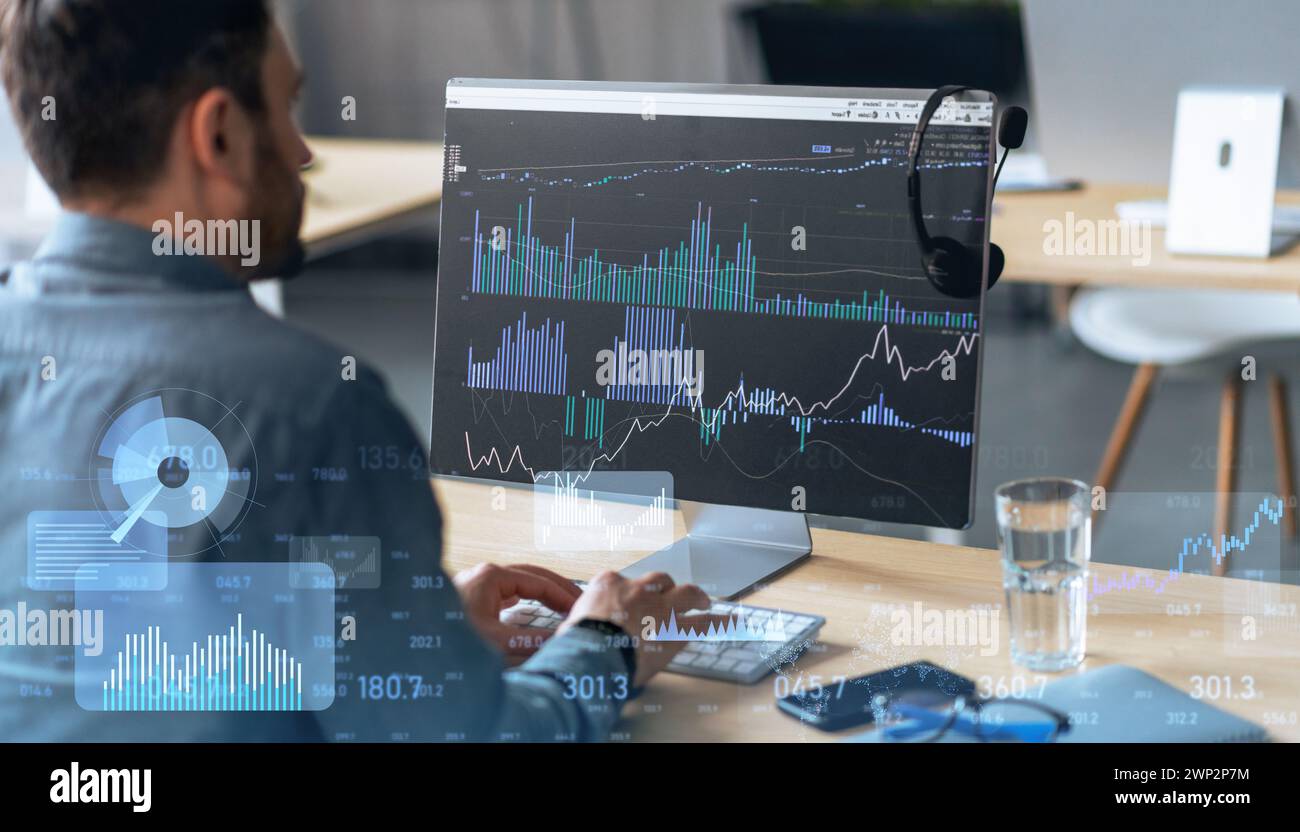 Focused man analyzing complex financial statistics on a computer monitor Stock Photo