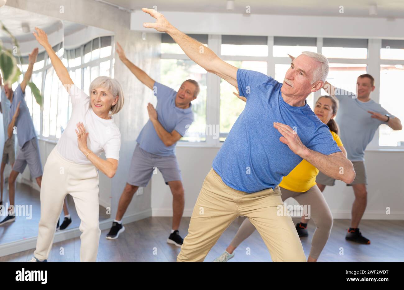 Elderly man learning dynamic dances at group choreography lesson Stock Photo