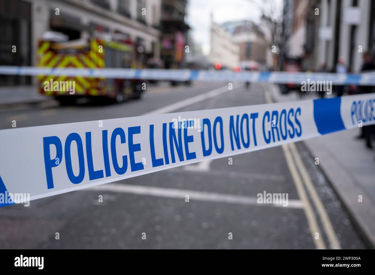 Police line, do not cross tape surrounding the aftermath of a double-decker bus crash which took place on New Oxford Street on 5th March 2024 in London, United Kingdom. Emergency services cordoned off the area following the accident in which a yellow Routemaster bus crashed into an empty building which was under redevelopment. No one has been reported as being seriously injured although one person was taken away for treatment. Stock Photo