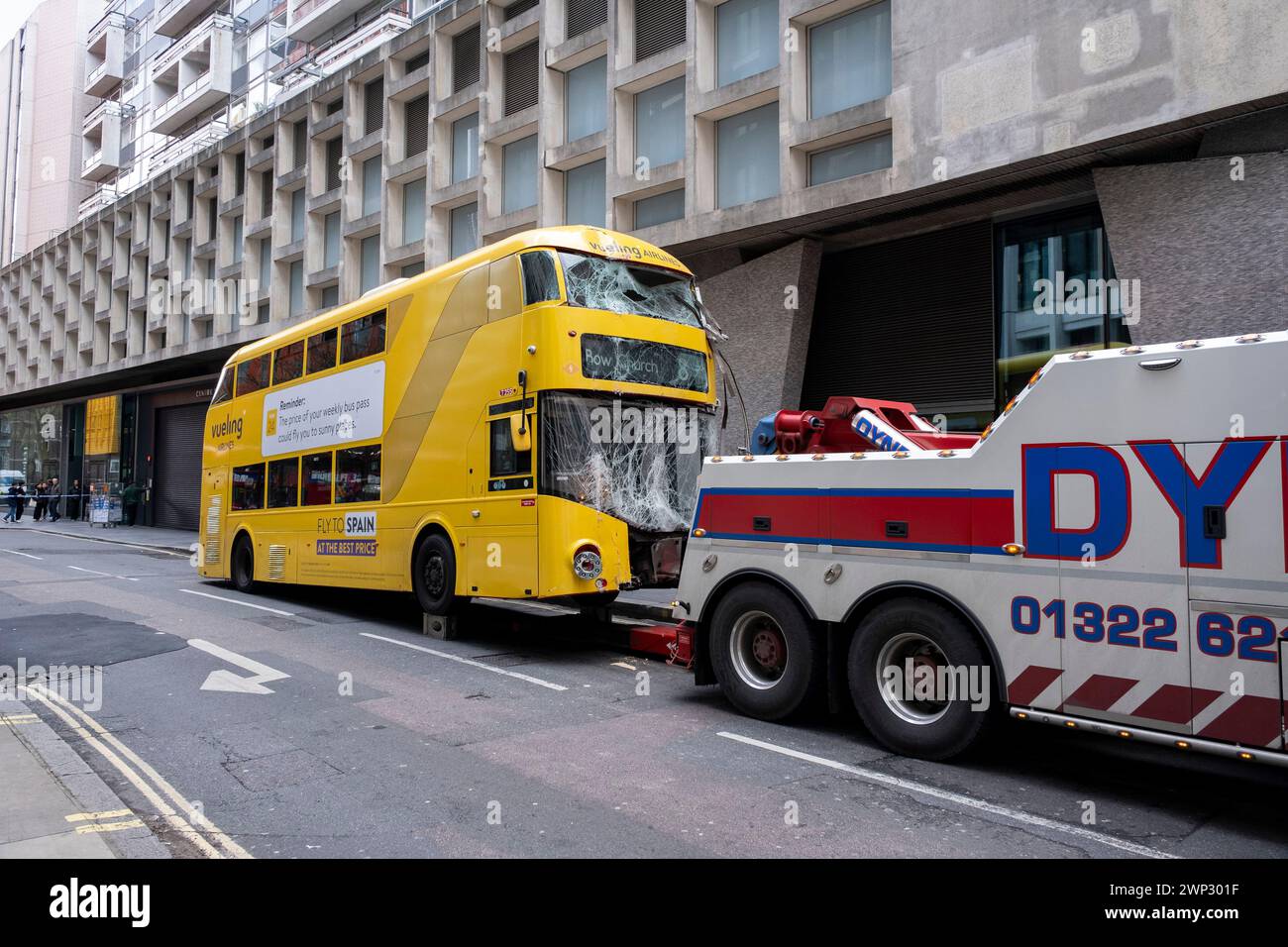 Aftermath of a double-decker bus crash which took place on New Oxford Street, and which was hitched to a recovery vehicle on 5th March 2024 in London, United Kingdom. Emergency services cordoned off the area following the accident in which a yellow Routemaster bus crashed into an empty building which was under redevelopment. No one has been reported as being seriously injured although one person was taken away for treatment. Stock Photo