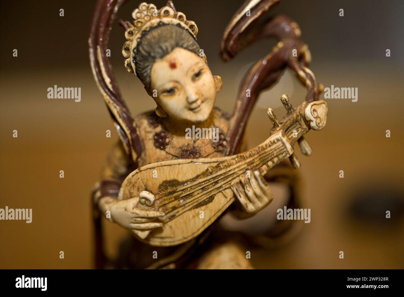 Carved ivory figurine, woman playing a pipa, traditional Chinese lute Stock Photo