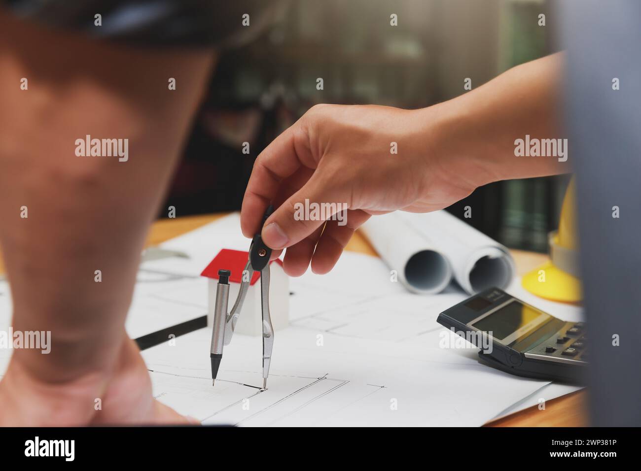 Engineer or architect using divider compass tools on blueprint in office on site. Stock Photo