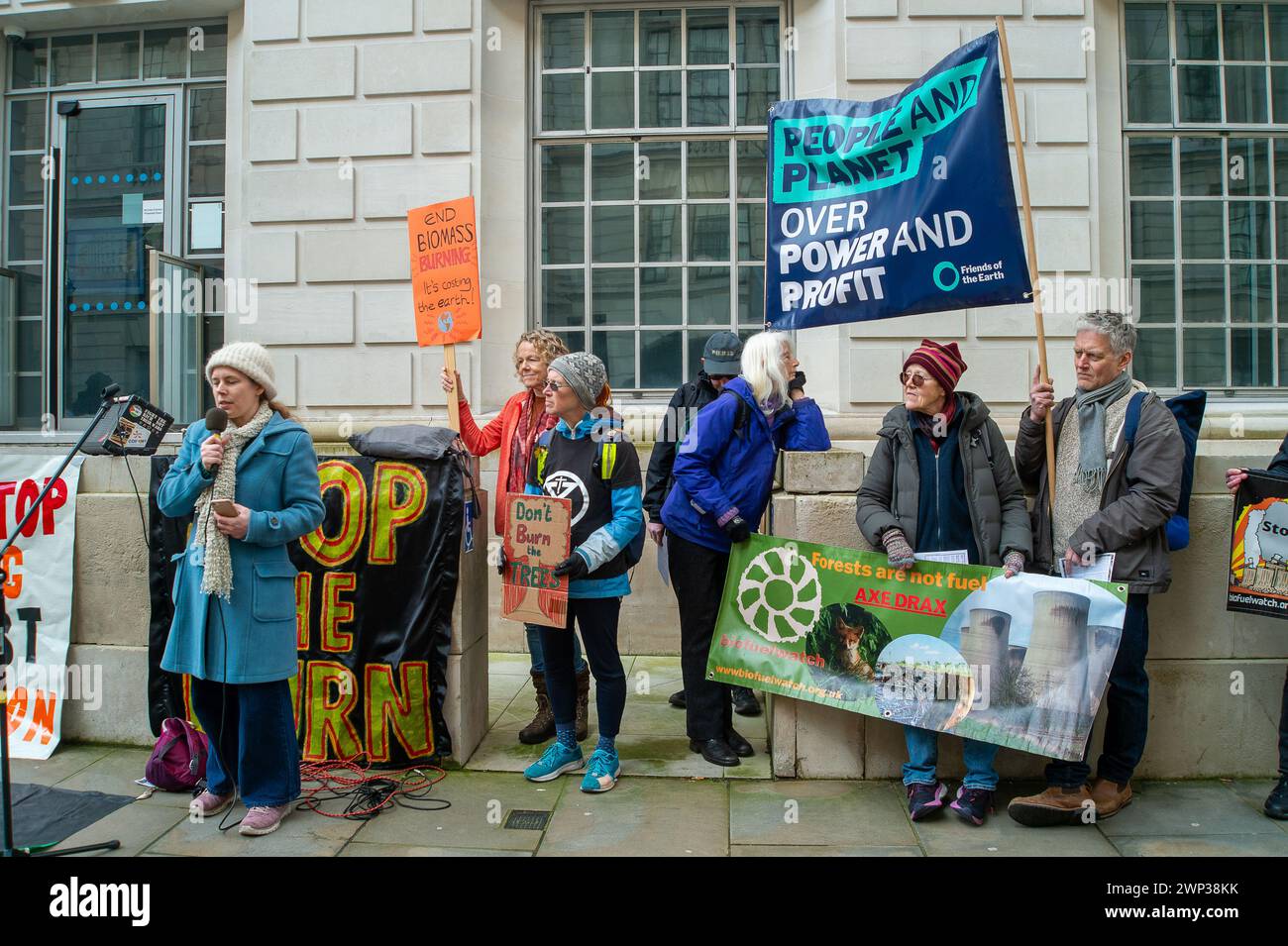 Whitehall, London, UK. 5th March, 2024. Protesters from Money Rebellion, Extinction Rebellion, Biofuelwatch, The Stop Burning Trees Coalition, Greenpeace, Stop Rosebank, and the Campaign Against Climate Change held a Stop Drax Emergency Demonstration outside the Department for Energy, Security and Net Zero today in London. The protesters say 'The UK Government is currently considering giving £ billions more in subsidies to dirty polluting tree burning power station Drax and Lynemouth. If approved the UK will locked into years more of tree burning at the cost of our forests, health and energy b Stock Photo