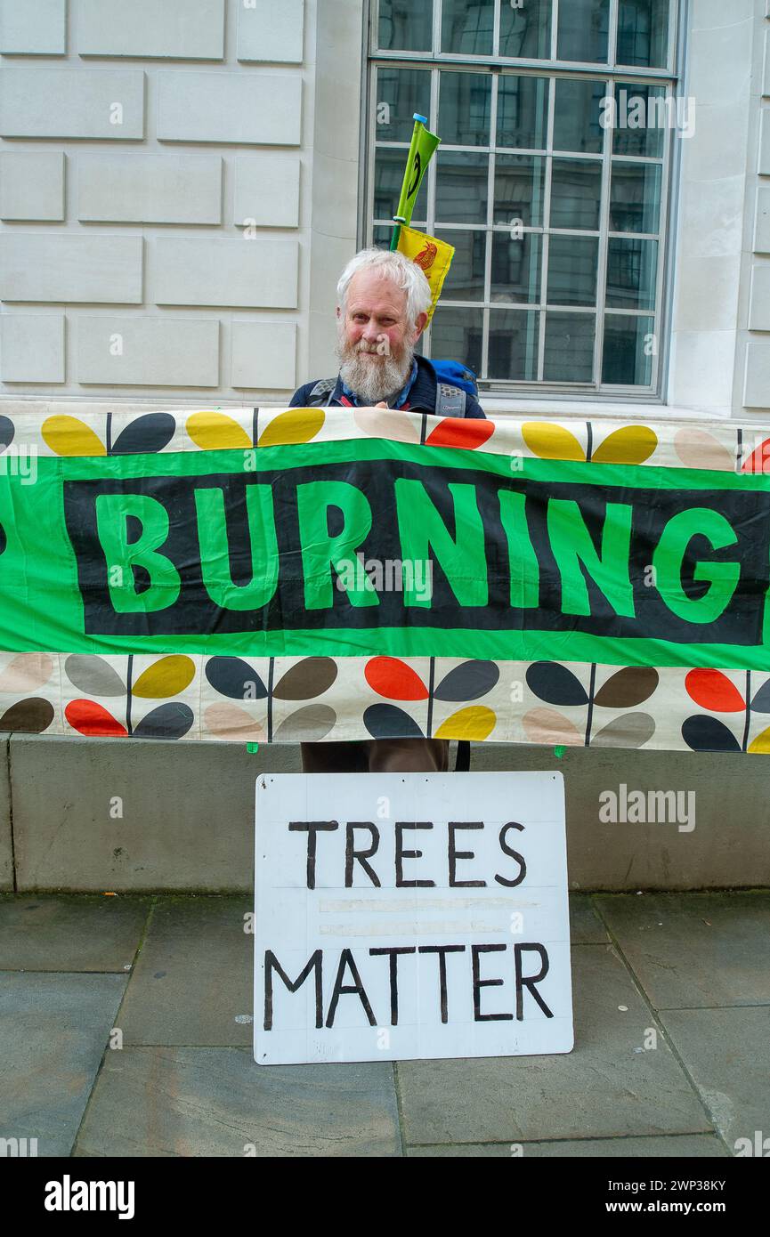 Whitehall, London, UK. 5th March, 2024. Protesters from Money Rebellion, Extinction Rebellion, Biofuelwatch, The Stop Burning Trees Coalition, Greenpeace, Stop Rosebank, and the Campaign Against Climate Change held a Stop Drax Emergency Demonstration outside the Department for Energy, Security and Net Zero today in London. The protesters say 'The UK Government is currently considering giving £ billions more in subsidies to dirty polluting tree burning power station Drax and Lynemouth. If approved the UK will locked into years more of tree burning at the cost of our forests, health and energy b Stock Photo