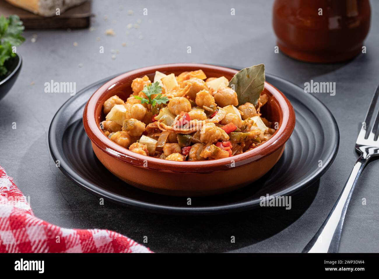 Ropa vieja, typical Canarian dish of chickpeas stew with chicken and potatoes in a earthenware casserole. Stock Photo