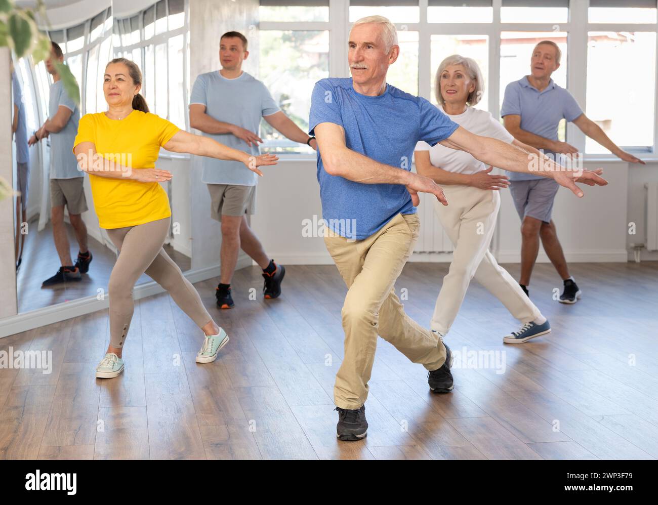 Elderly man learning dynamic dances at group choreography lesson Stock Photo
