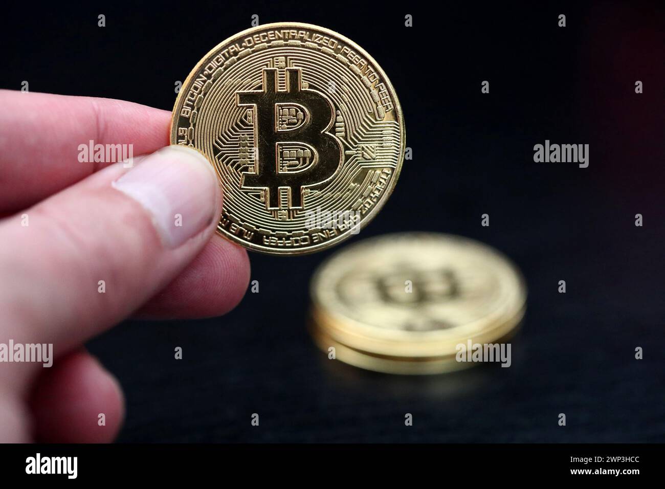 Symbolbild:  Eine Hand hält einen Bitcoin - Der Bitcoin steht hoch im Kurs. Selbst Finanzdienstleister wie Paypal wollen die Kryptowährung als Zahlung Stock Photo