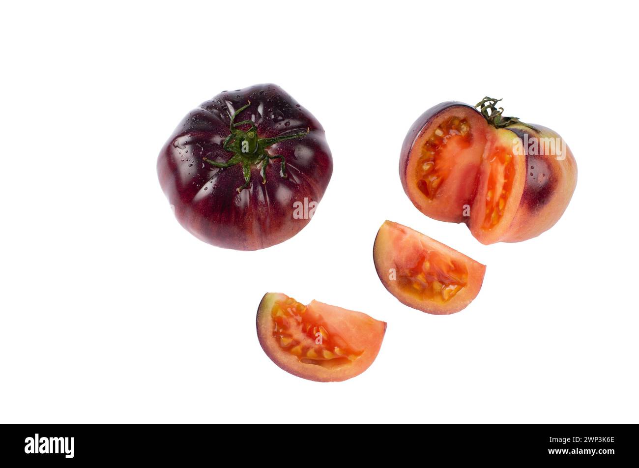 Fresh ribbed Antociano tomatoes on white background. Stock Photo