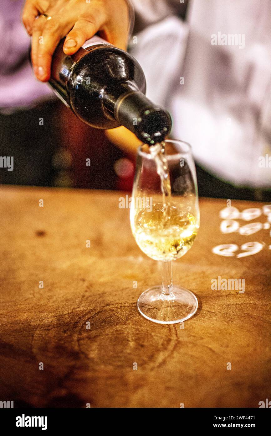 A waiter serves a glass of fino sherry at a woodpaneled bar in Seville