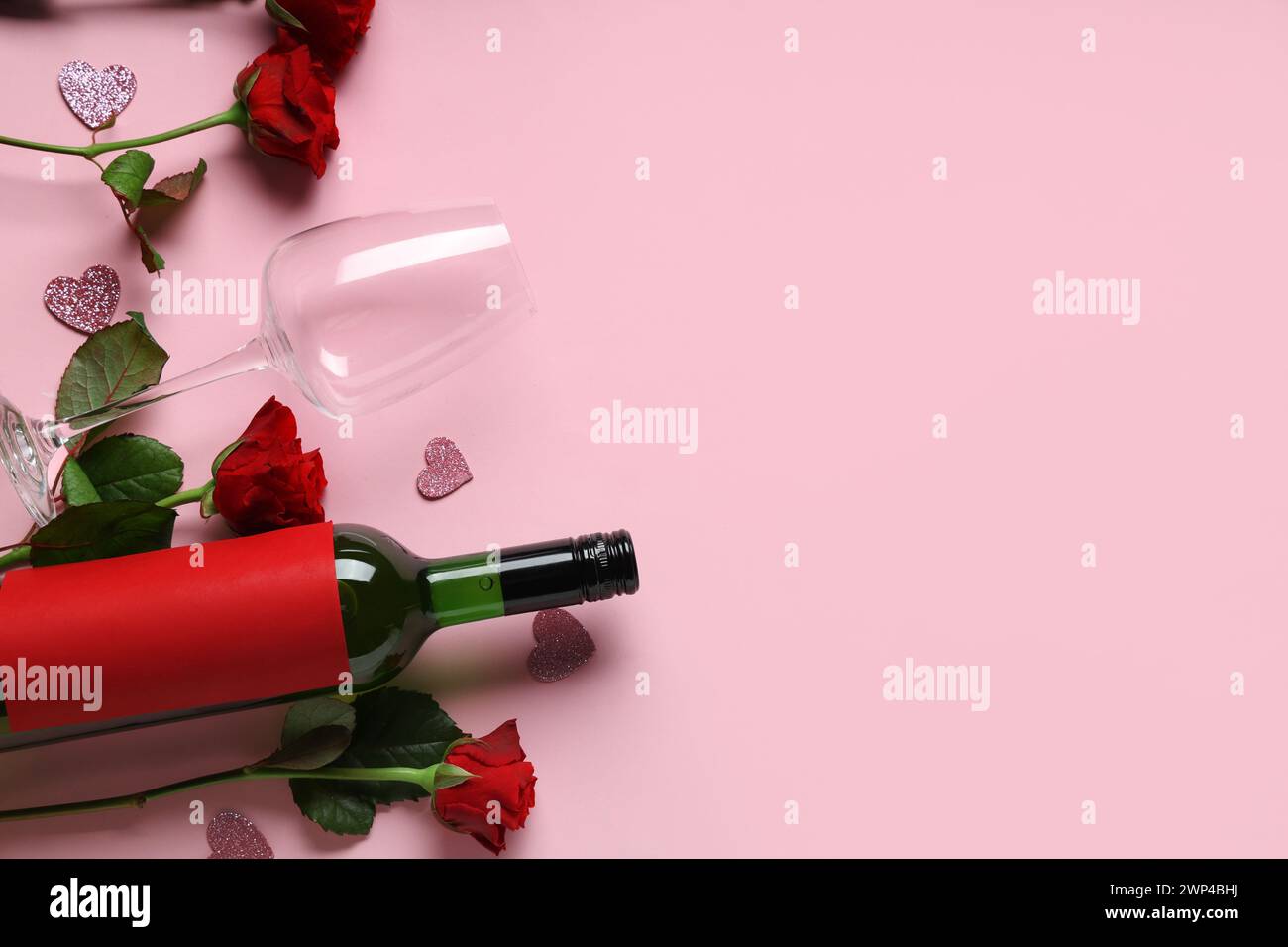 Bottle of wine with glasses and red roses on pink background. Valentine ...