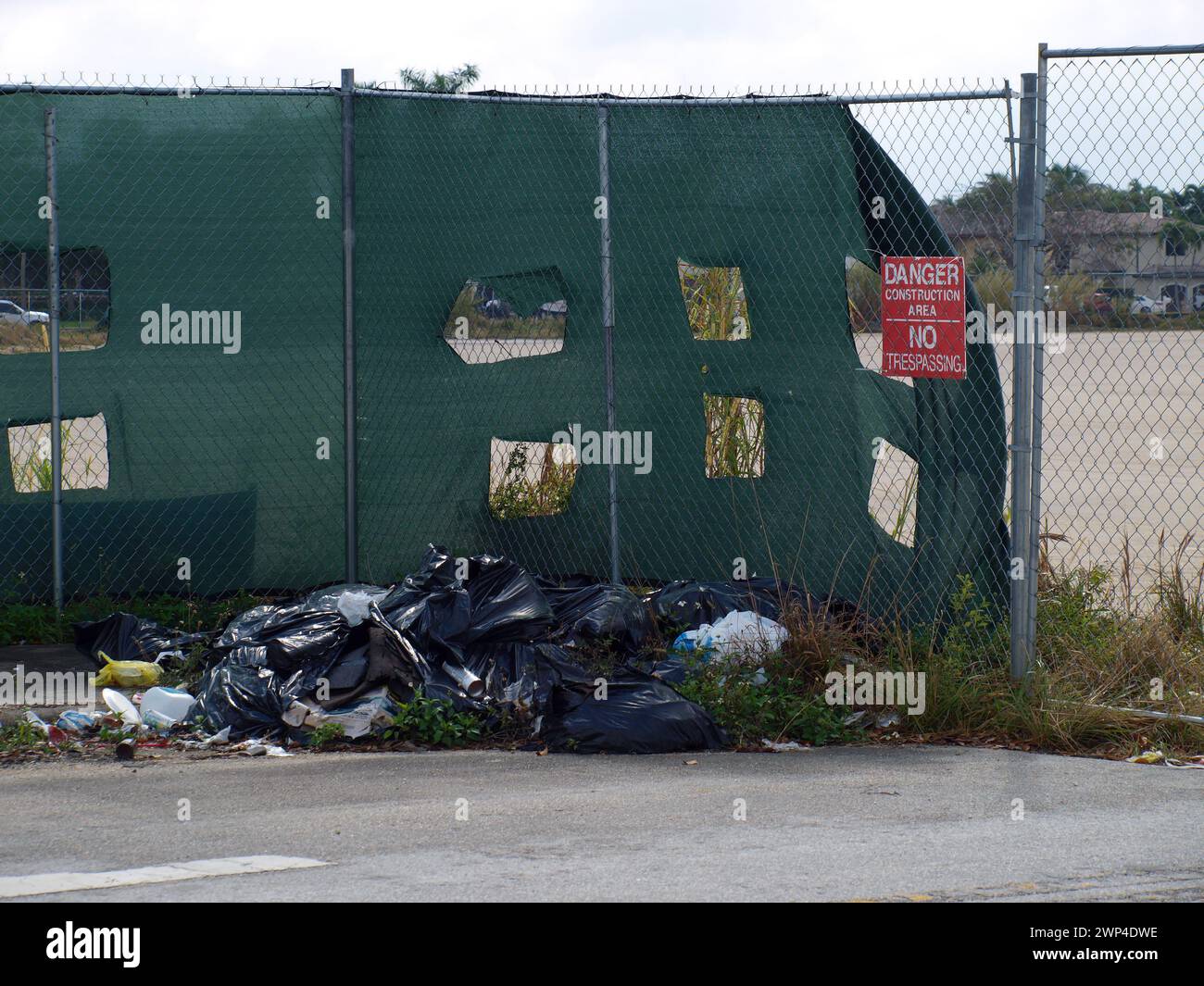 Miami, Florida, United States - February 24, 2024: Garbage left at the entrance of a construction site. City trash pollution. Stock Photo