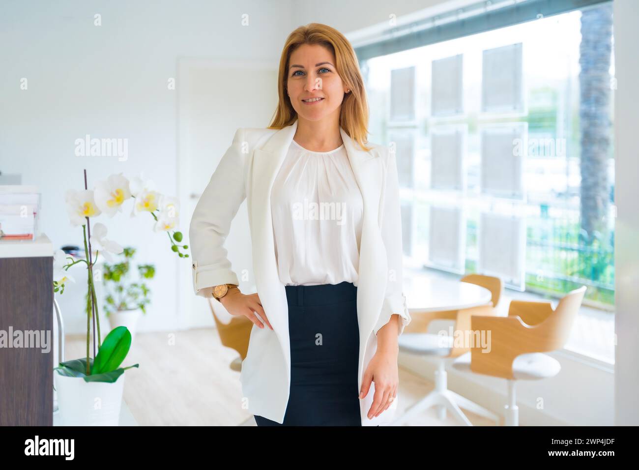 Horizontal portrait of a female chic real estate agent standing proud in the office Stock Photo