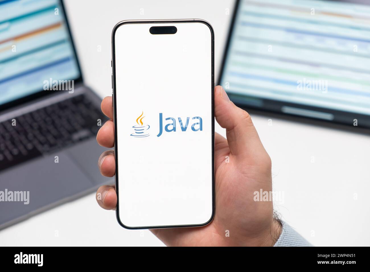 PRAGUE, CZECH REPUBLIC - JANUARY 21 2024: Java logo on the screen of smartphone in mans hand on the workplace background.  Stock Photo