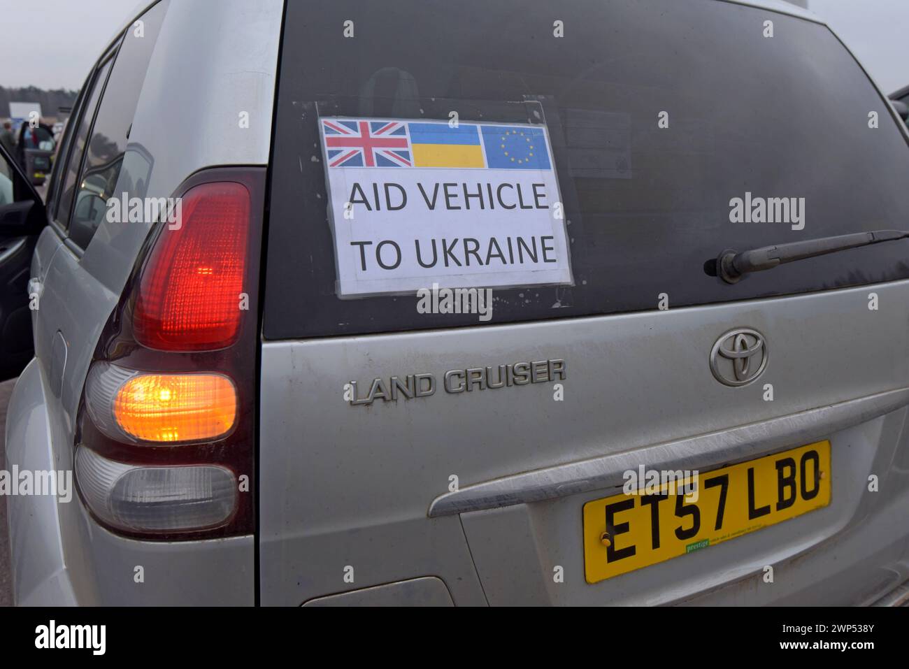Stickers with Ukrainian flags in the window of a 4x4 vehicle on an aid
