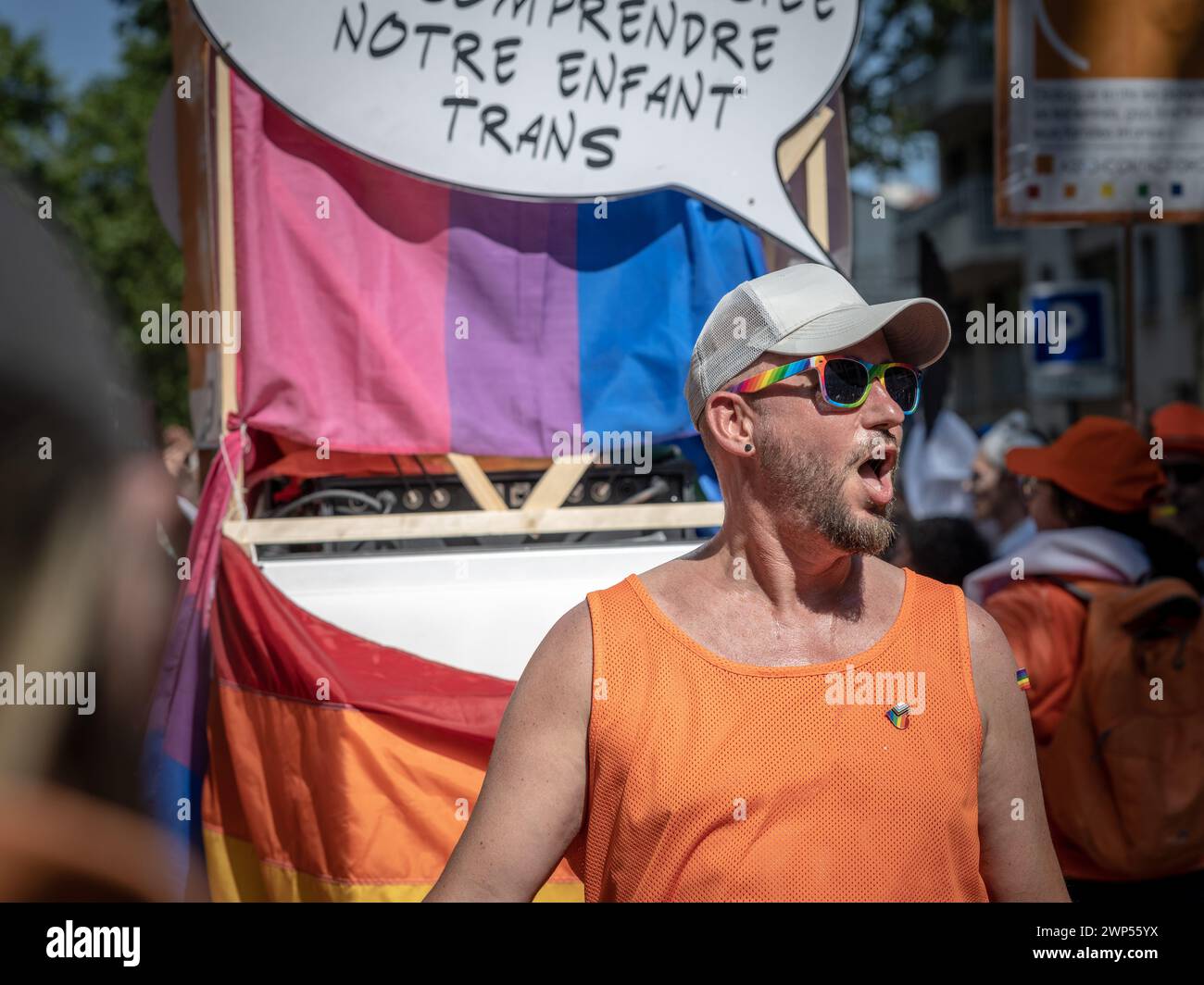 Paris, France - June 24, 2023: A man shouting underneath poster in French at the 2023 Paris gay pride on which it says something about a trans child Stock Photo