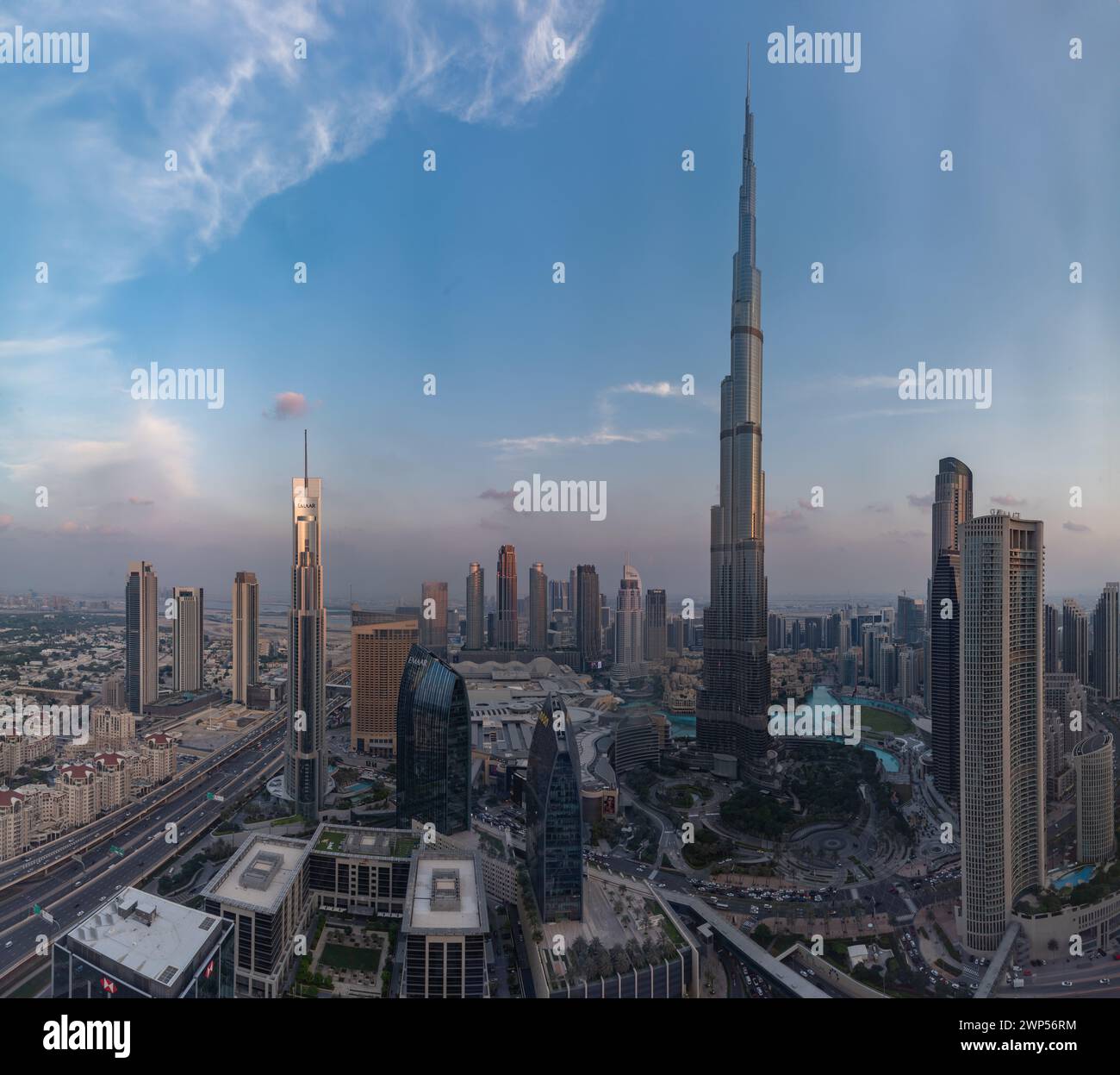 A picture of the Burj Khalifa towering the buildings of the nearby Downtown Dubai, Business Bay and Zabeel 2 districts, at sunset. Stock Photo