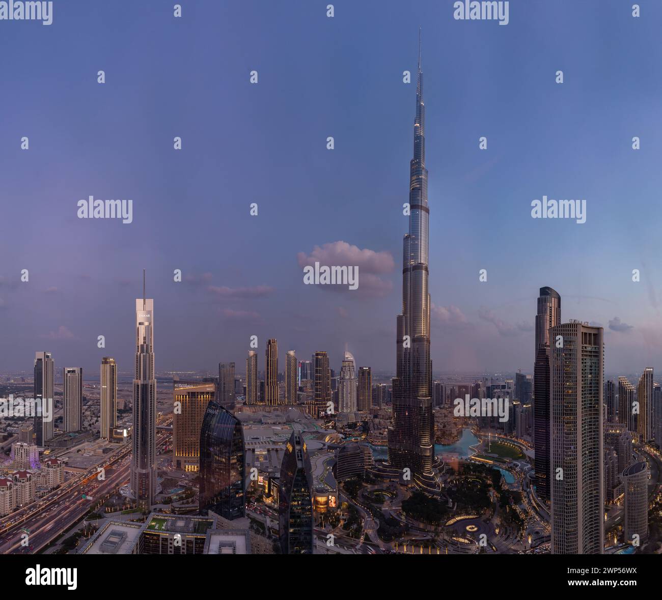 A picture of the Burj Khalifa towering the buildings of the nearby Downtown Dubai, Business Bay and Zabeel 2 districts, at sunset. Stock Photo