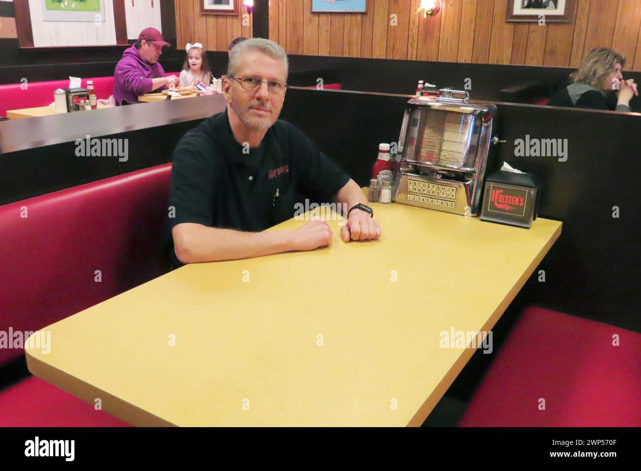 Ron Stark, co-owner of Holsten's, the Bloomfield N.J. ice cream parlor and restaurant where the final scene of 'The Sopranos' TV series was filmed, sits on March 5, 2024, at a recreation of the booth where Tony Soprano may or may not have met his end. The day before, the original booth used in the show was was sold in an online auction for $82,600 to a buyer that wishes to remain anonymous. (AP Photo/Wayne Parry) Stock Photo