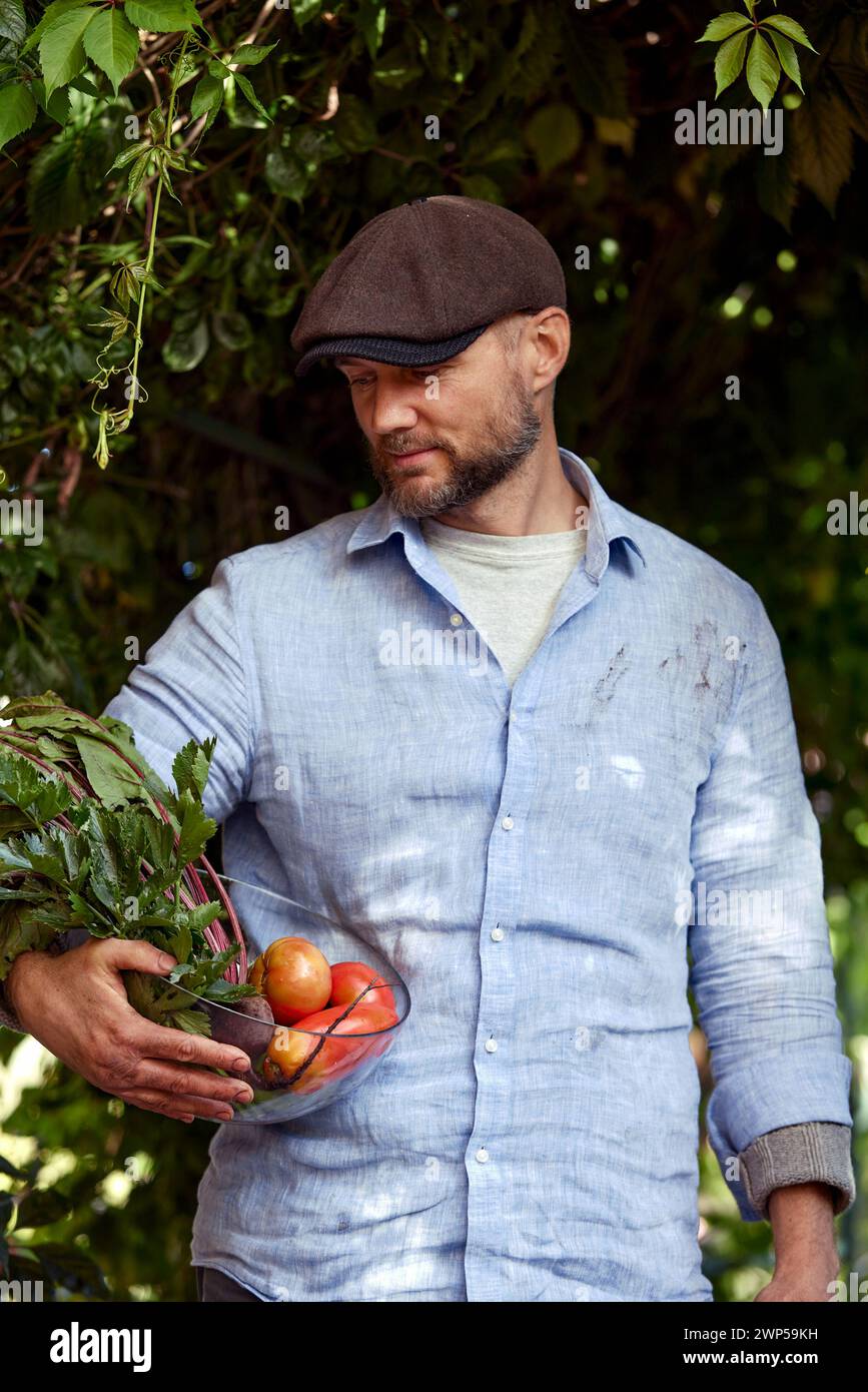 Happy farmer with a basket full of seasonal vegetables Stock Photo - Alamy