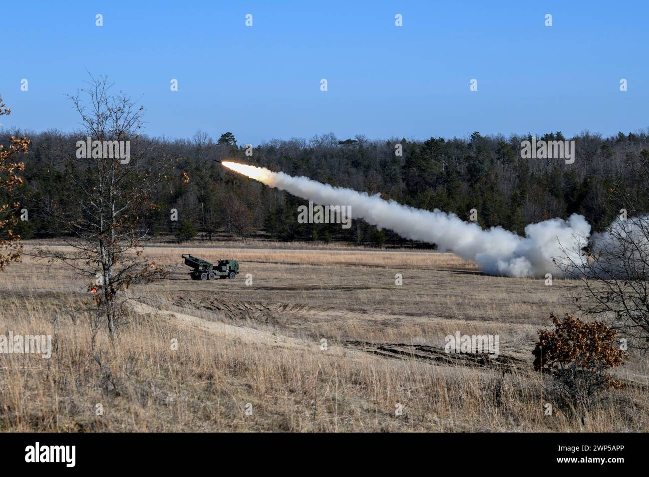 A pair of M142 High Mobility Artillery Rocket System (HIMARS) with Bravo Battery, 1st Battalion, 182nd Field Artillery Regiment, Michigan Army National Guard, fire their rockets during a winter live-fire exercise on Camp Grayling, Michigan, March 2, 2024. Members of the unit conducted a Table VI qualification for section chiefs. (U.S. Army National Guard photo by Daniel Garas) Stock Photo