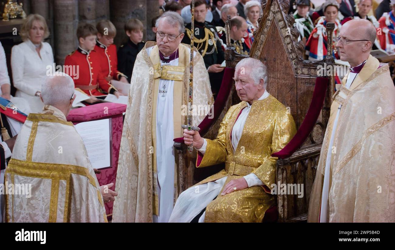 King Charles III Coronation service, holding gemstone-encrusted 'Jewelled Sword of Offering'. Given to the king with the order that 'it should be used for the protection of good and the punishment of evil,' Westminster Abbey Westminster London UK 6th May 2023 Stock Photo