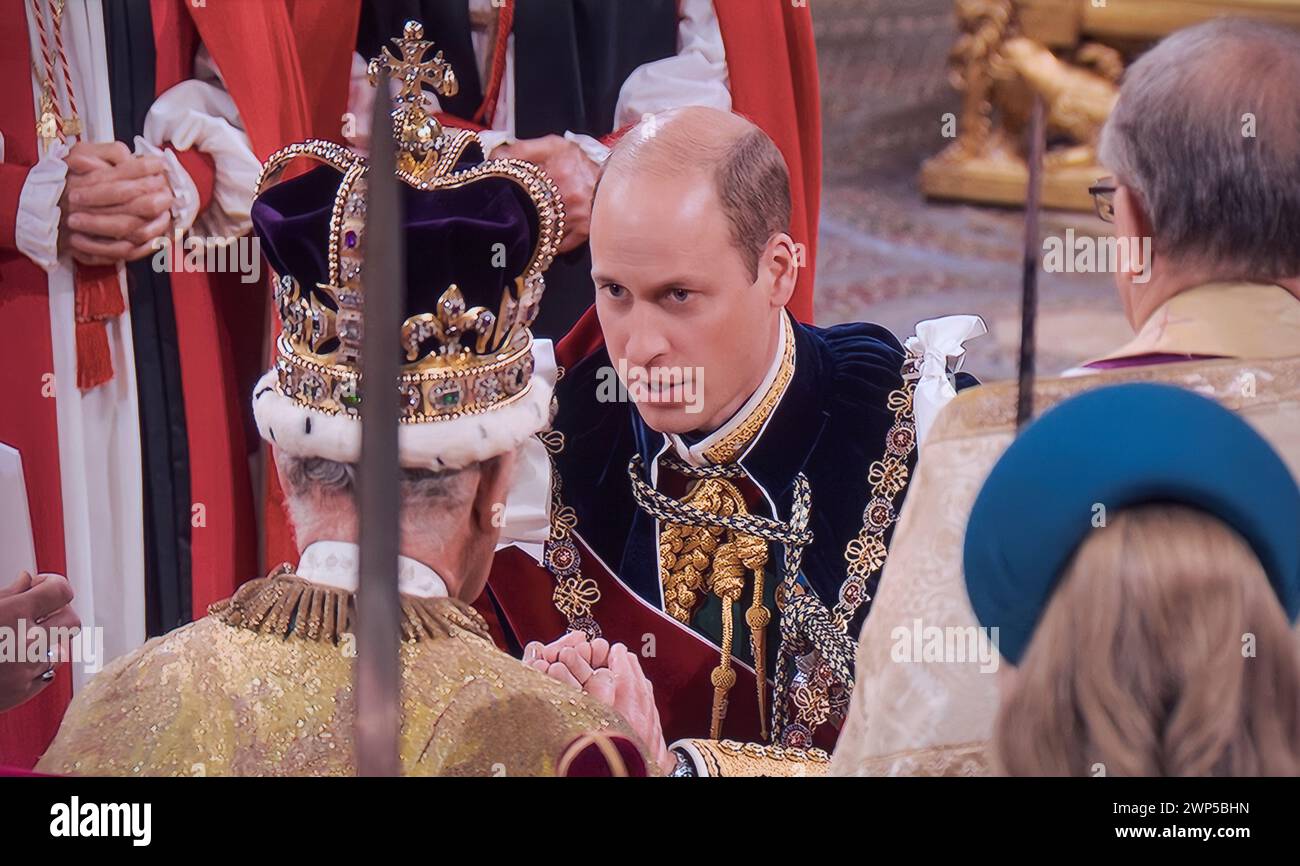King Charles III Coronation Homage 6th May 2023 with Prince William, Prince of Wales, Duke of Cambridge, kneels before his father King Charles III, and places his hands between the hands of the King and says: 'I, William, Prince of Wales, pledge my loyalty to you and faith and truth I will bear unto you, as your liege man of life and limb. Westminster Abbey Westminster London UK Stock Photo