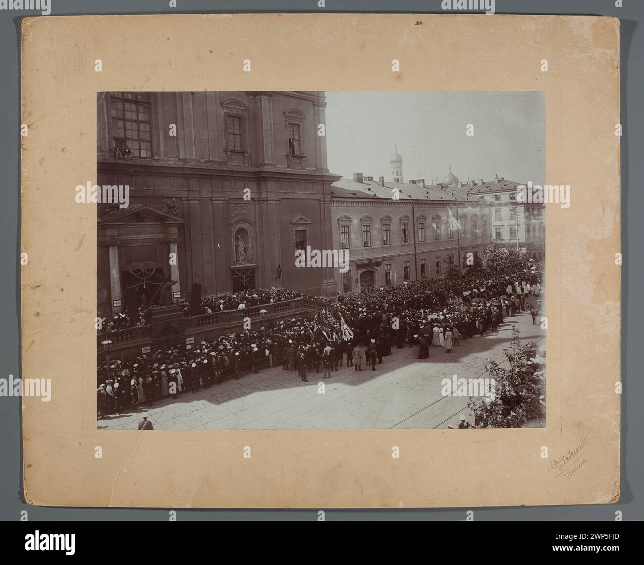A photograph from 27 August 1902 depicting the funeral of Henryk Siemiradzki in Krakowskie Przedmieście, Warsaw, showing the procession, church, tram rails, funeral wreaths, and attendees. Stock Photo