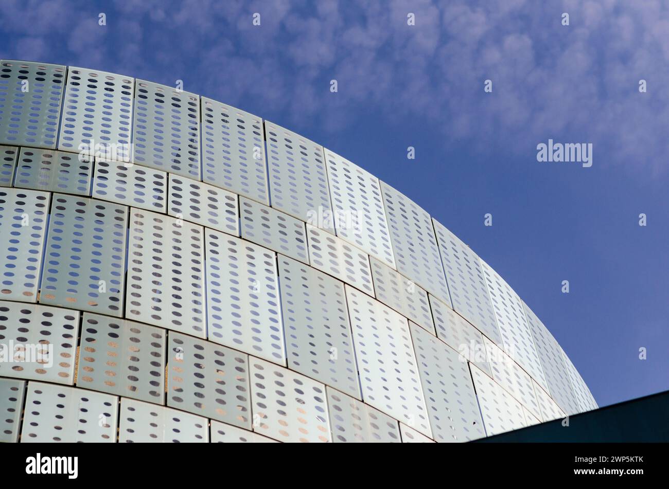 Modern building facade, with innovative designed solar protection system on a south-facing glass facade. semicircular building, with wavy lines of mol Stock Photo