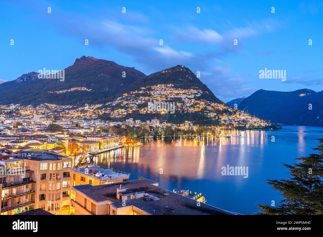 Lugano, Switzerland cityscape with Monte Bre on Lake Lugano at night. Stock Photo