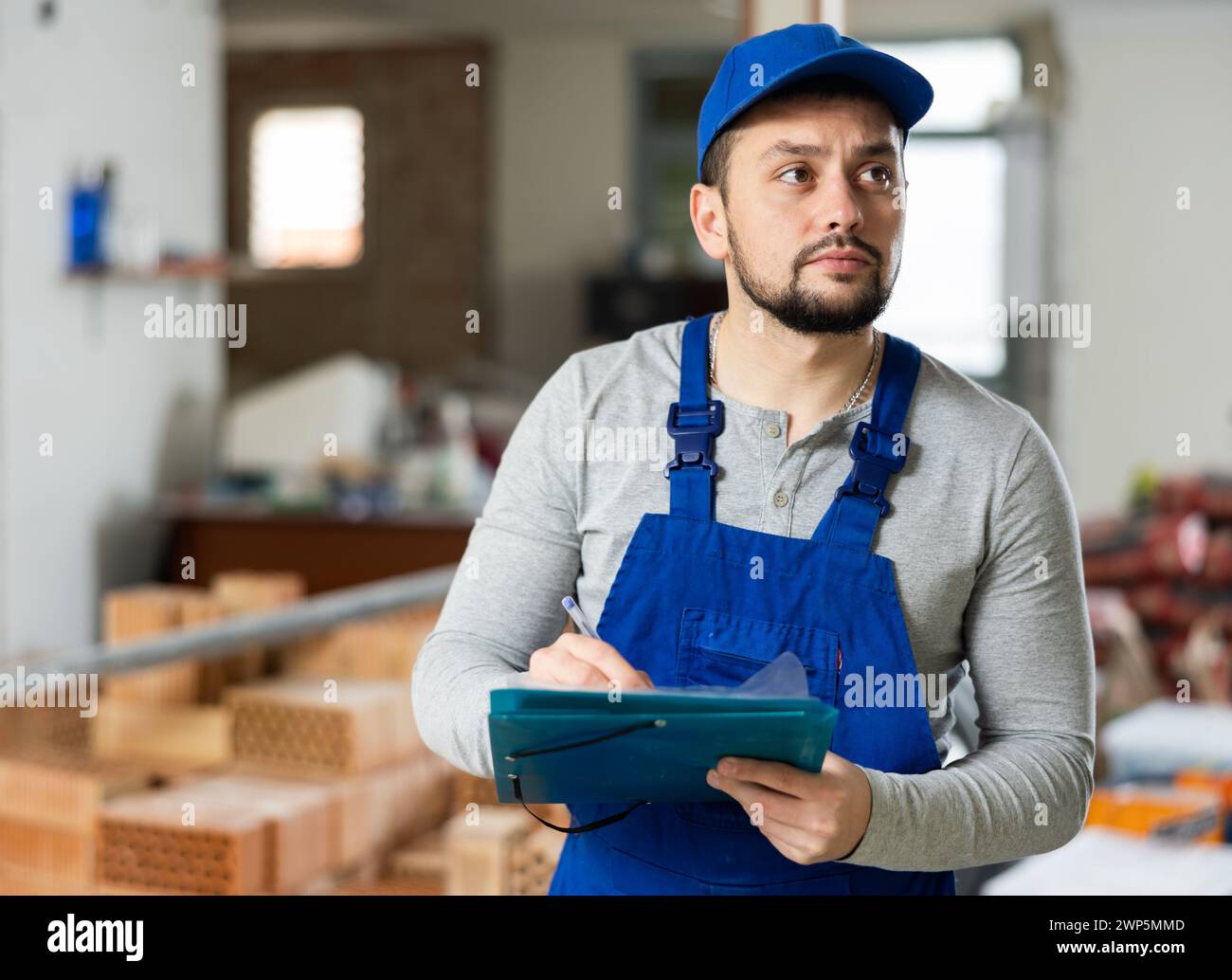 Foreman making task list during works in building under construction Stock Photo