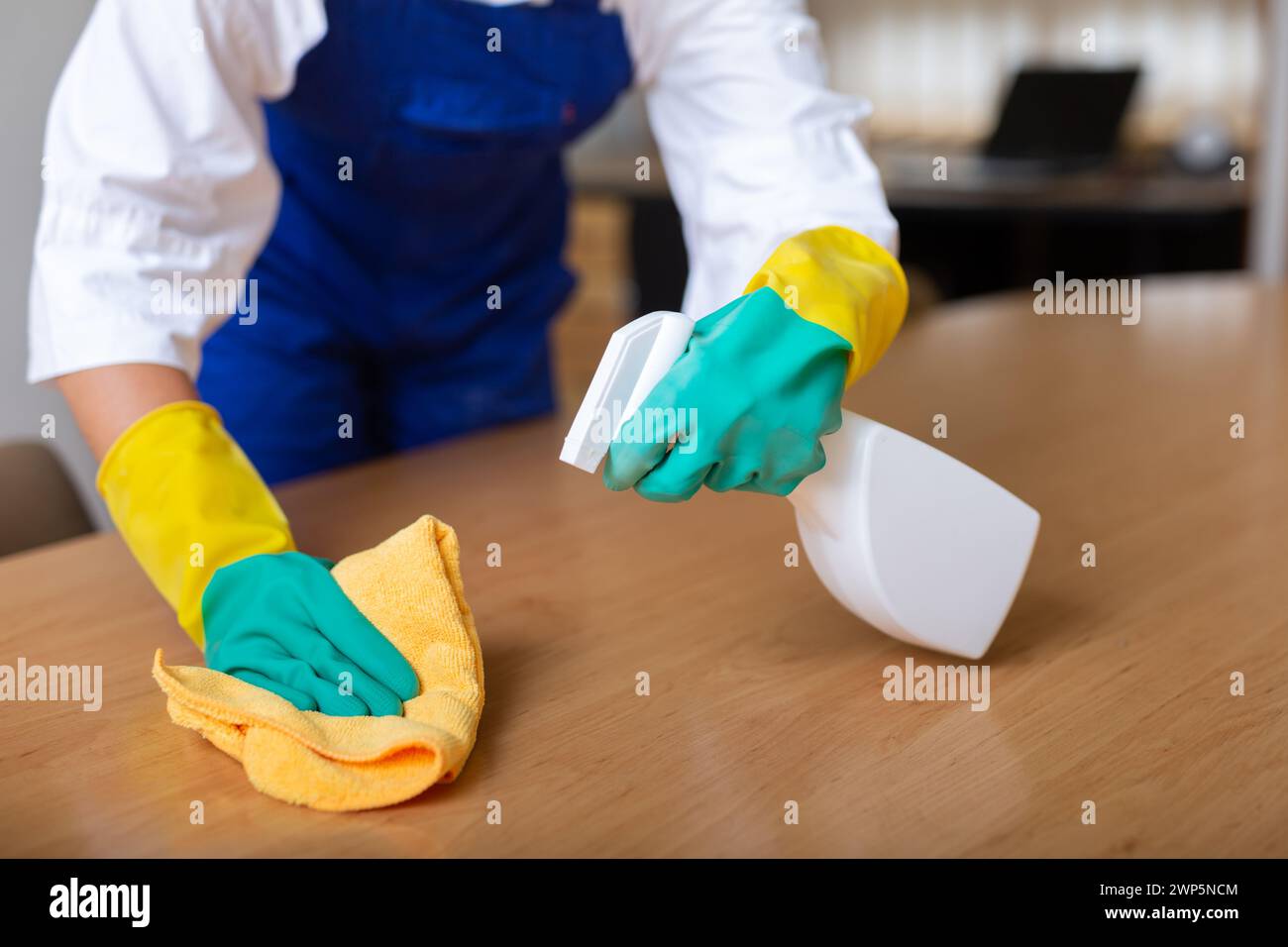 Worker cleaning table with rag and detergent Stock Photo - Alamy