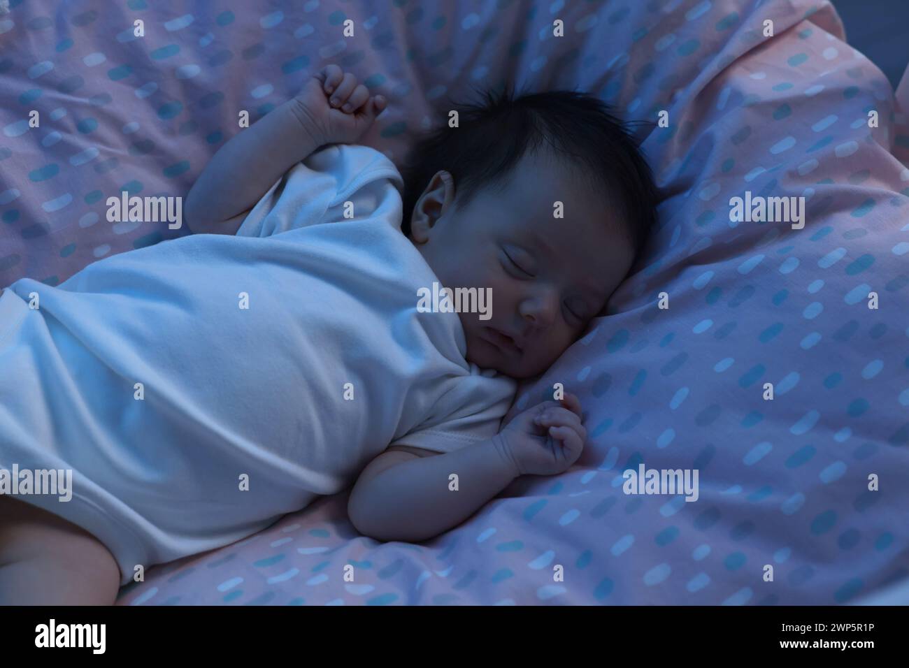 Cute newborn baby sleeping in crib at night Stock Photo