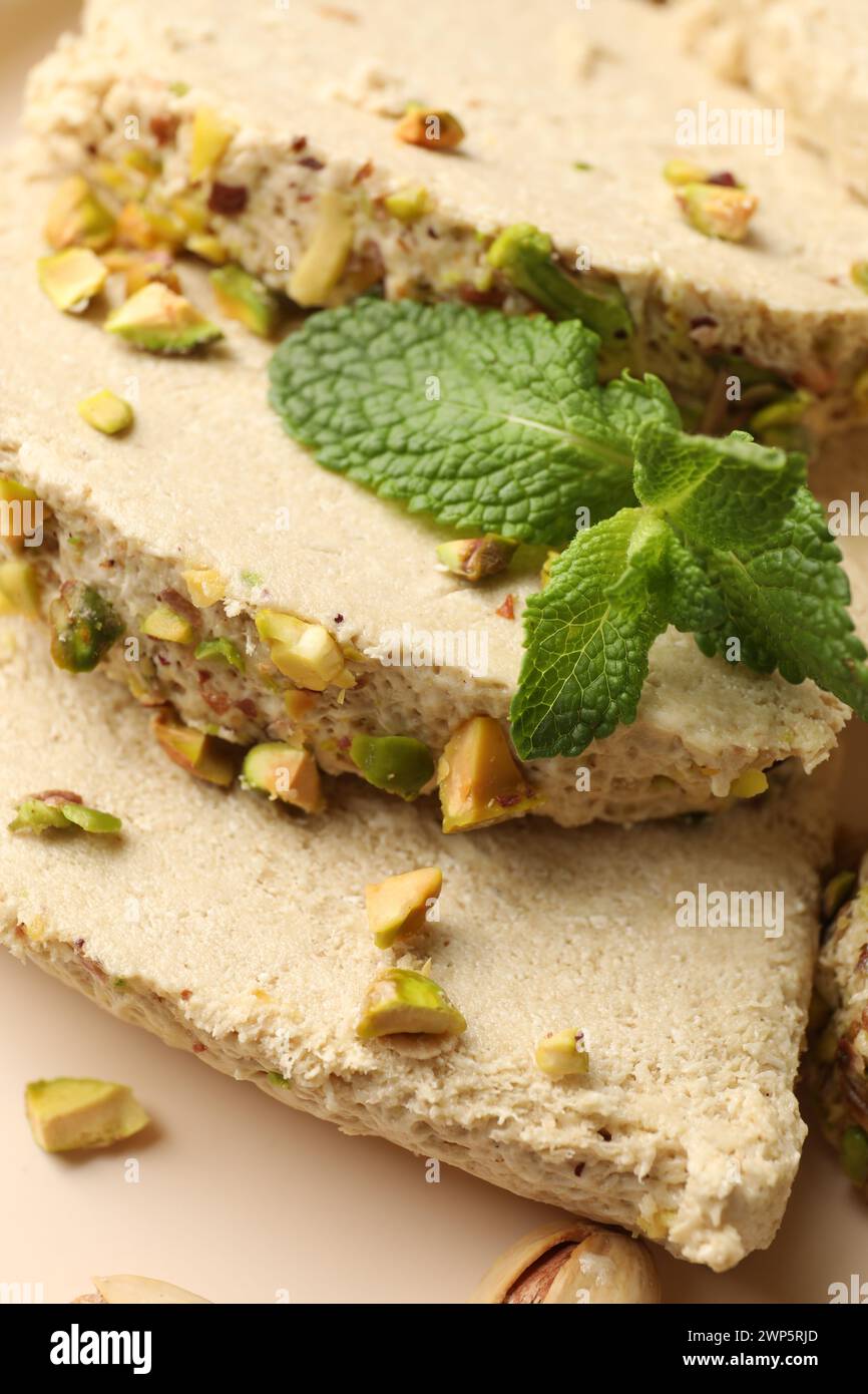 Pieces of tasty halva with pistachios and mint on table, above view ...