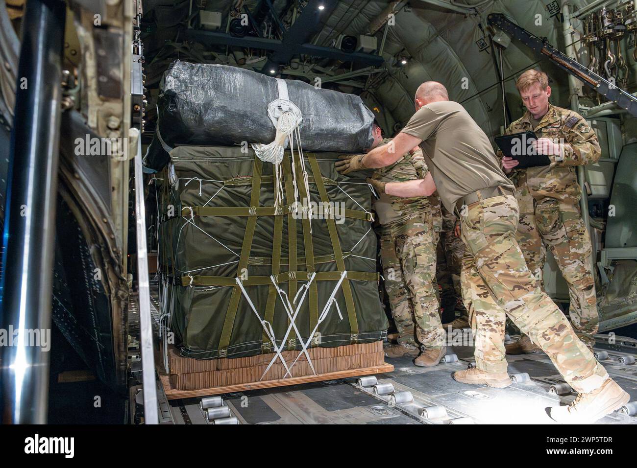Washington, United States. 04th Mar, 2024. U.S. Airmen and Soldiers load pallets of humanitarian aid aboard a C-130J Super Hercules at an undisclosed location within the U.S. Central Command area of responsibility, on Tuesday, March 5, 2024. The pallets are rigged with parachutes by U.S. Army Central Command Soldiers, transported to an aerial port where U.S. Air Forces Central Airmen load them aboard aircraft, and then released by U.S. Air Force loadmasters above dropzones in Gaza. Photo via U.S. Air Force Courtesy/UPI Credit: UPI/Alamy Live News Stock Photo