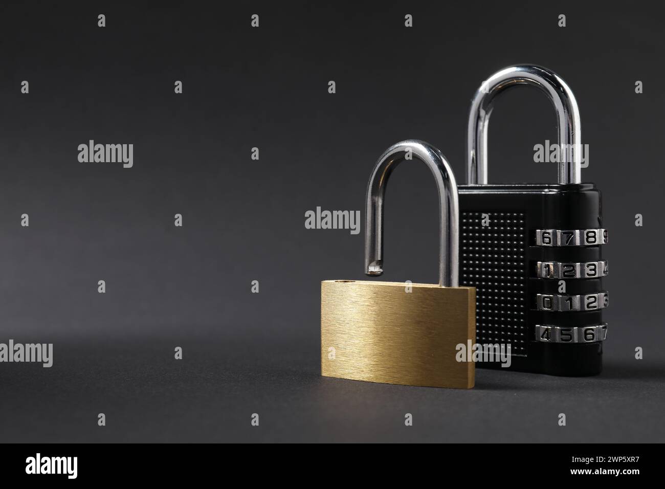 Different padlocks on black background, closeup. Space for text Stock Photo