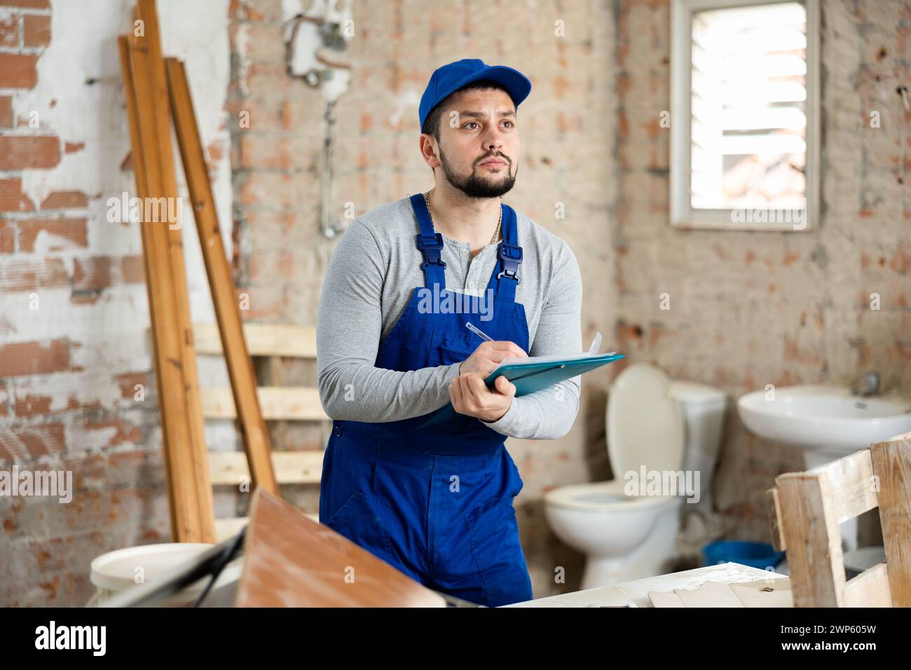 Builder making notes on indoor construction site Stock Photo