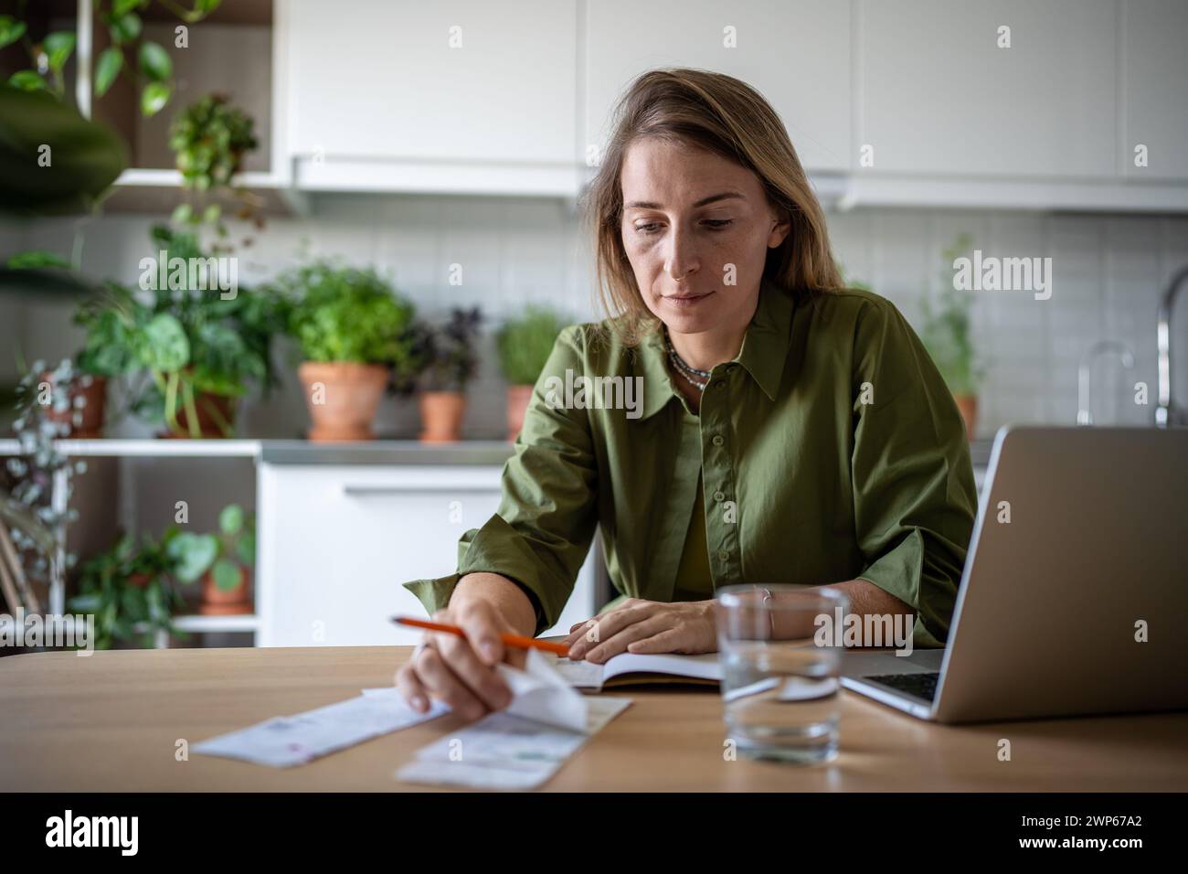 Freelance accountant analysing company invoices, verifying bills, checking income, savings at home Stock Photo