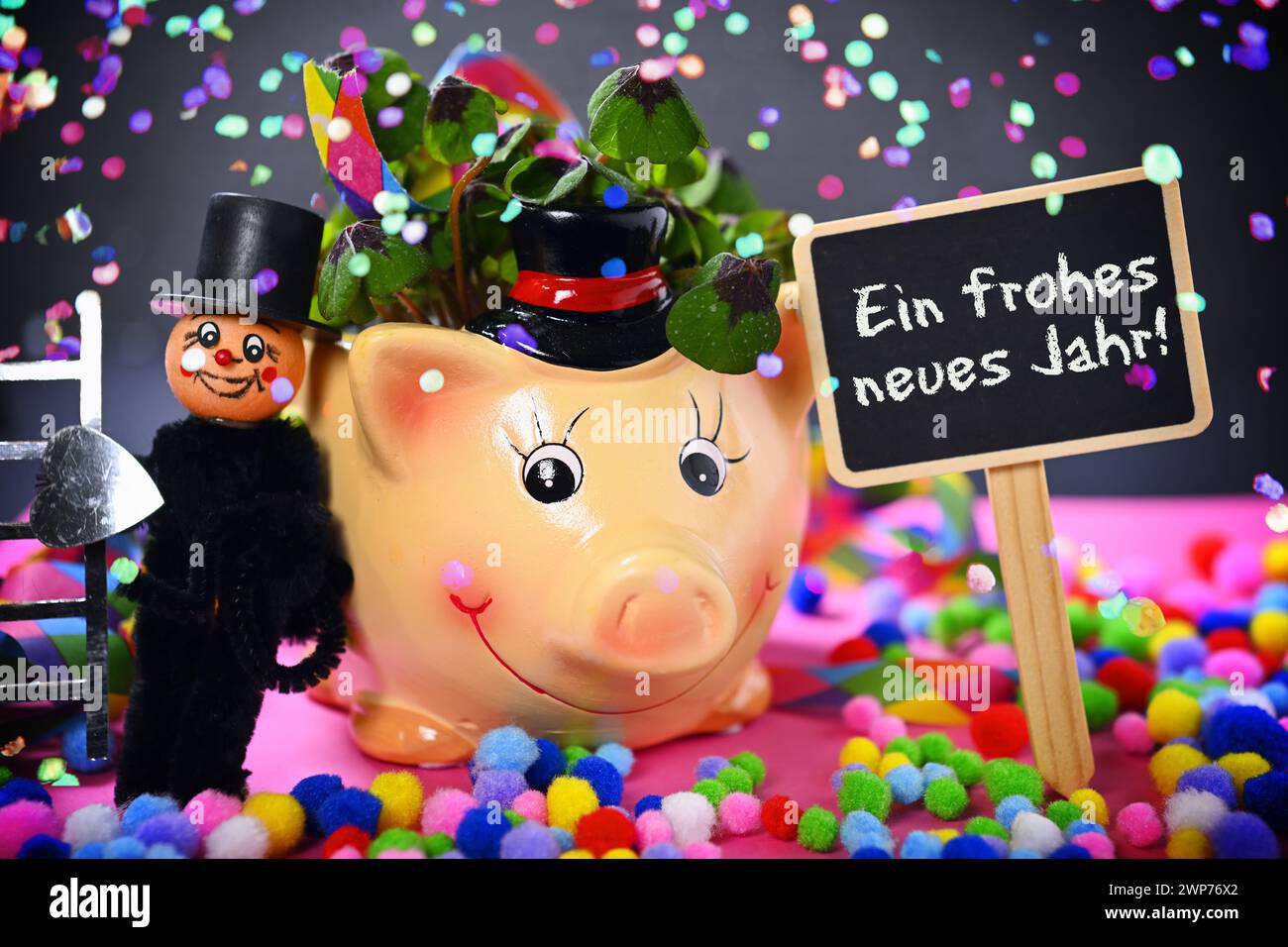 FOTOMONTAGE, Glücksschwein mit Kleeblättern, Schornsteinfegerfigur und Schild mit Aufschrift Ein frohes neues Jahr! mit Konfetti Stock Photo